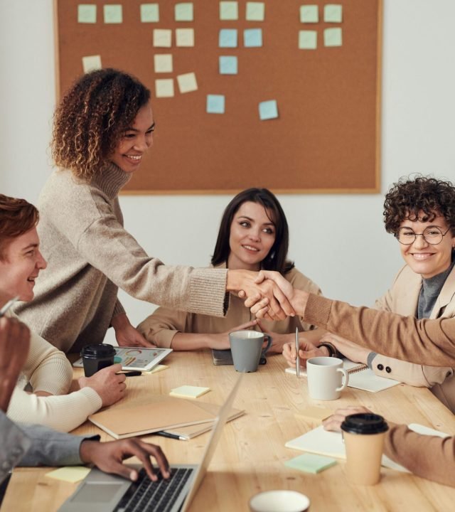 Diverse team collaborating in a meeting, showcasing teamwork and cooperation in a modern workplace.